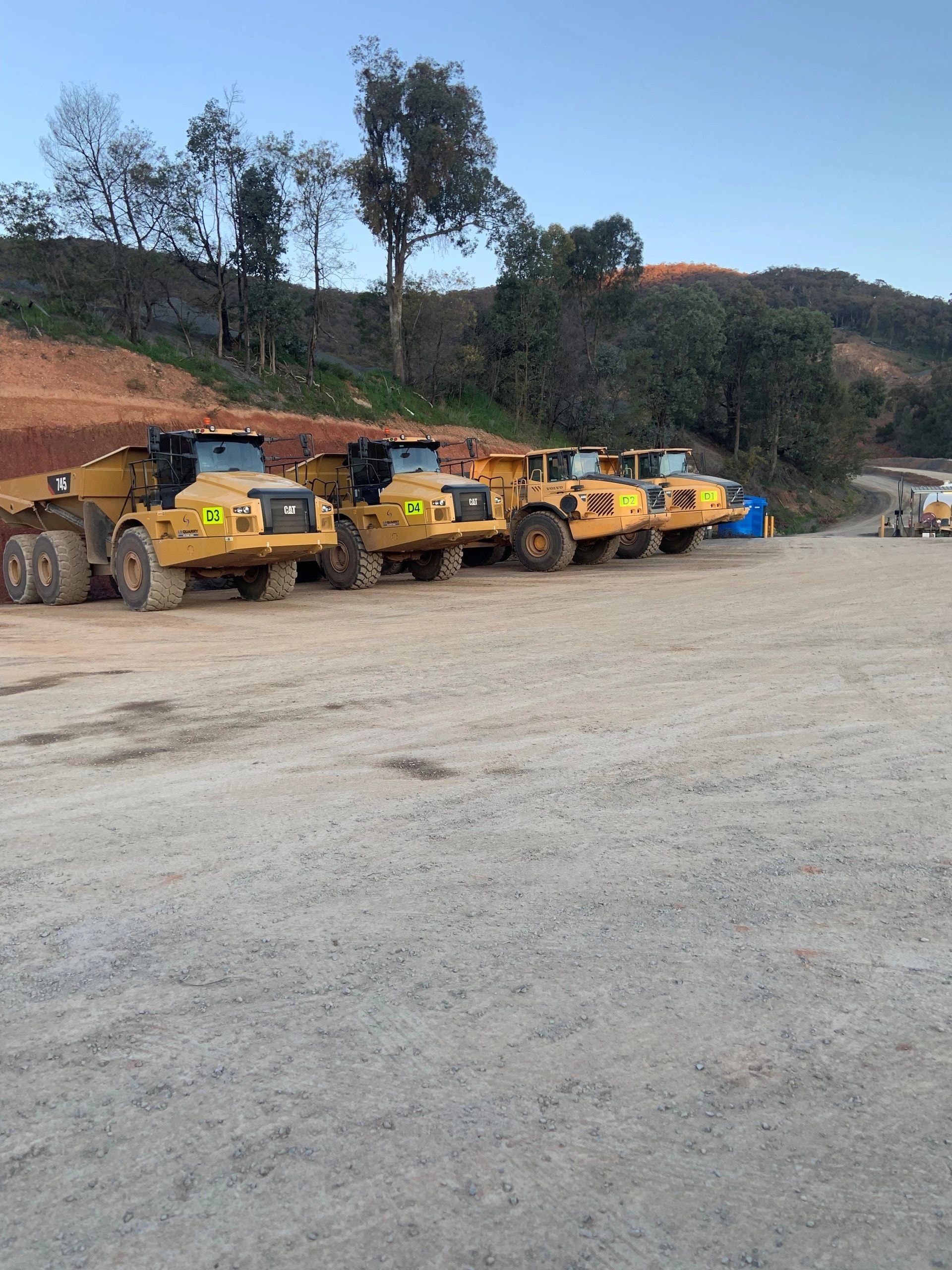 Fleet of articulated dump trucks at mining site